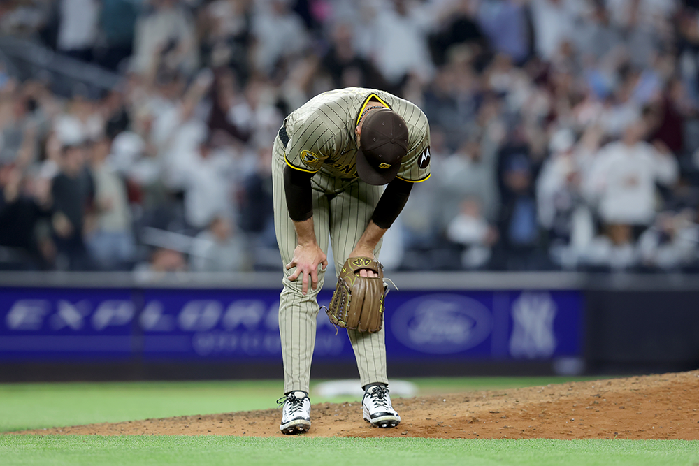 Jason Adam fully bent over at the waist, hands on knees, after surrendering a home run. The picture is from directly in front of him, so you can't see his face at all, just the top of his head.